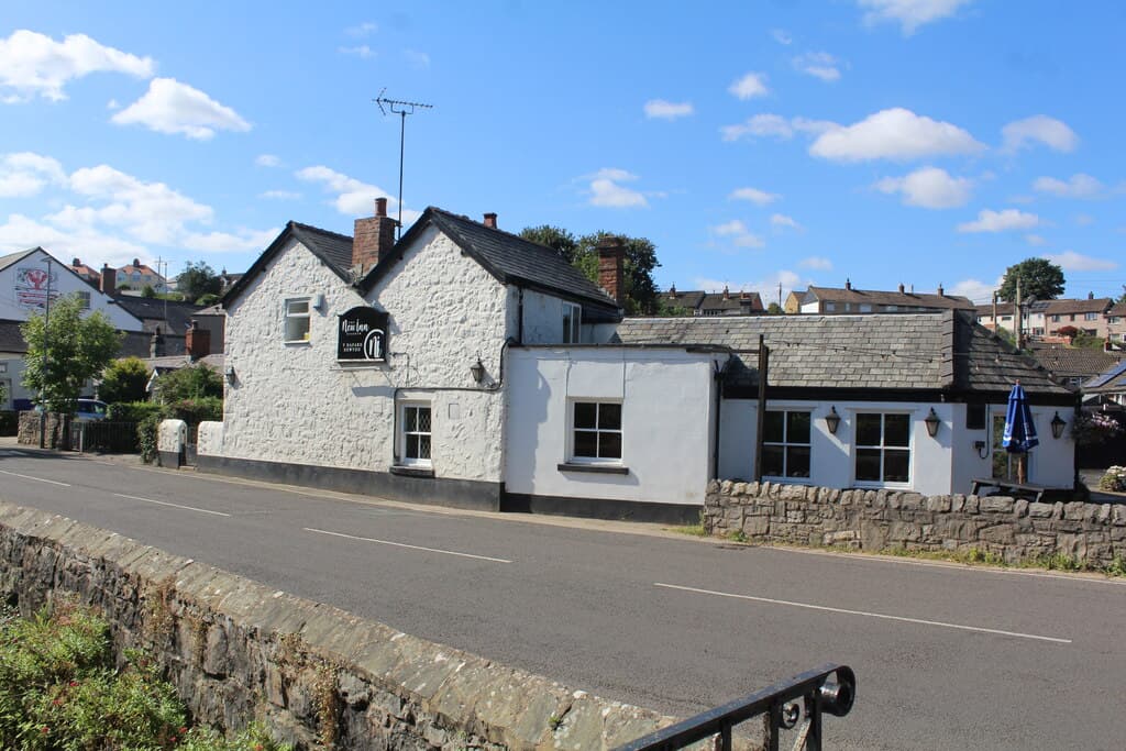 The New Inn at Dyserth, a whitewashed old village pub beside the road under a blue sky